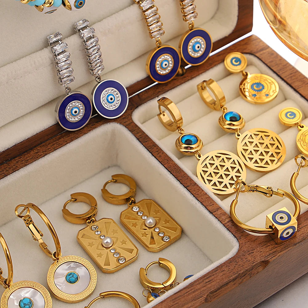 Assorted gold-tone evil eye dangle earrings with blue enamel details