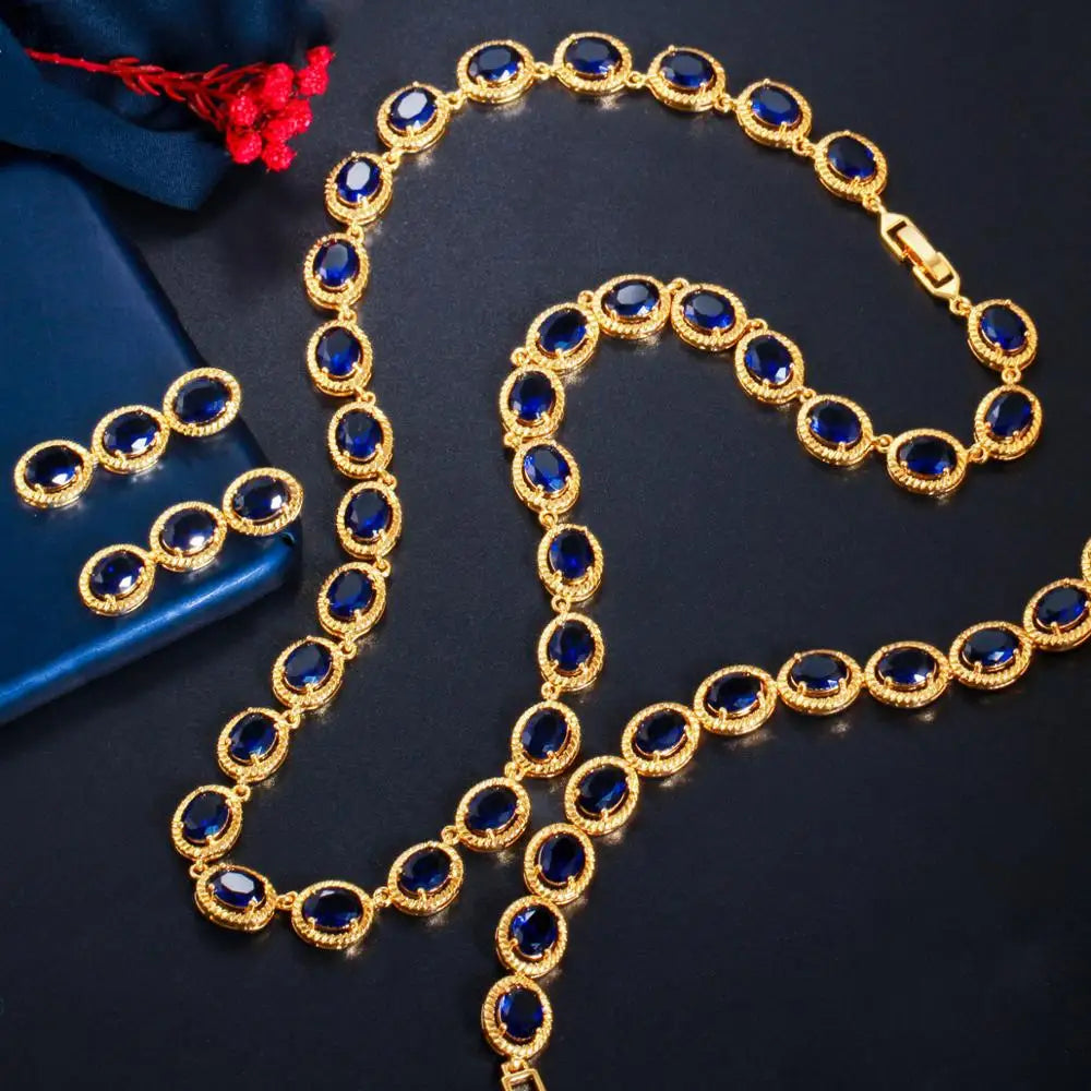Gold-tone oval blue zircon necklace and matching earrings laid flat