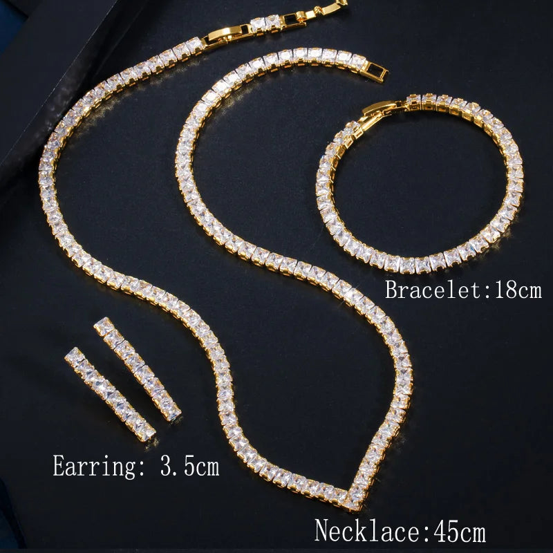 Gold cubic zirconia jewelry set with layered necklace, oval bracelet, and hoop earrings