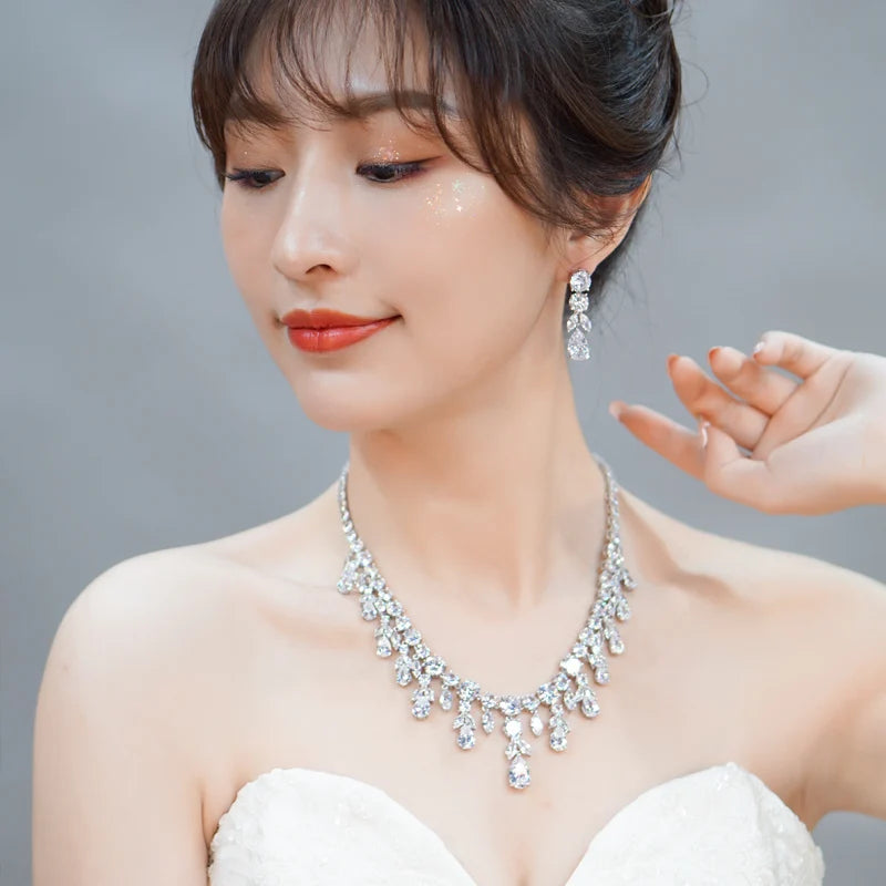 Rhinestone necklace with matching drop earrings worn by a woman