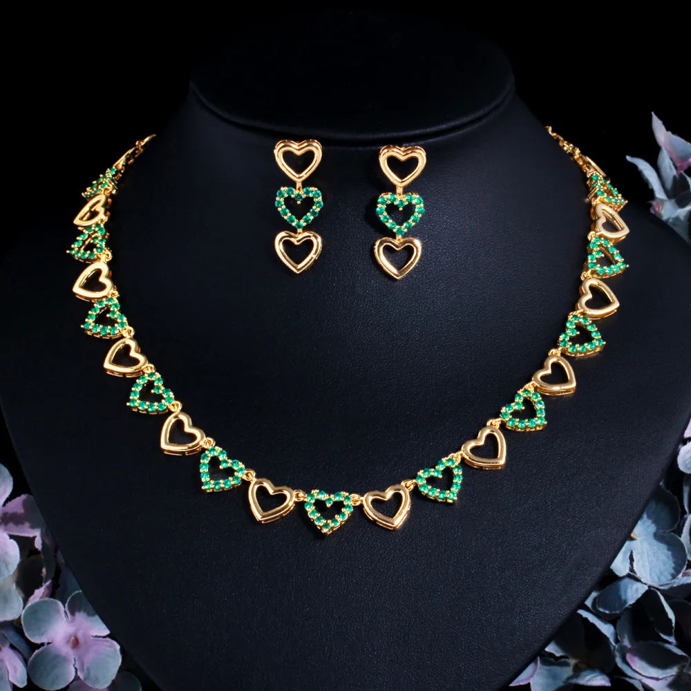 Gold-tone necklace and drop earrings with alternating open and green jeweled hearts