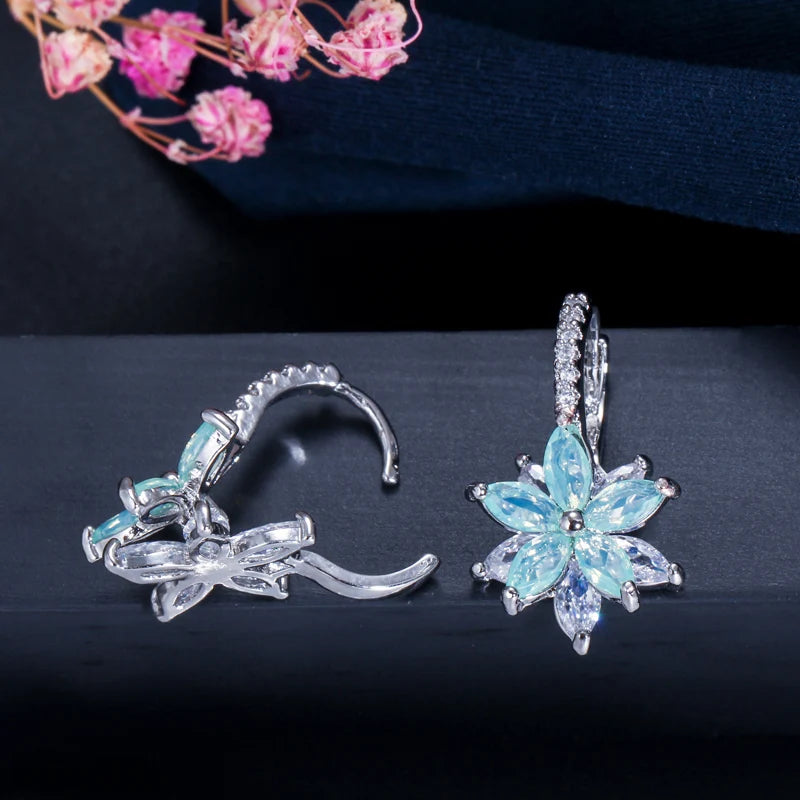 Pale blue flower earrings shown front and side, with clear-stone hoops