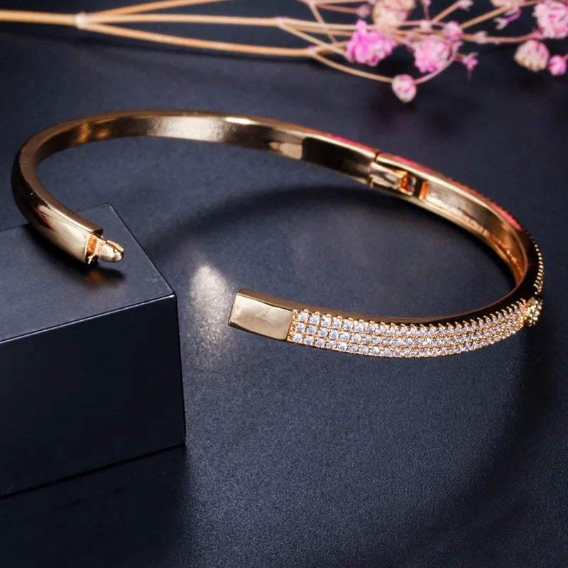 Gold-tone bangle bracelet with pave crystal accent and hinged clasp