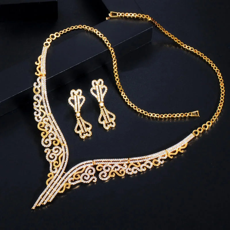 Gold-tone bridal jewelry set featuring a V-shaped scrollwork necklace and matching earrings