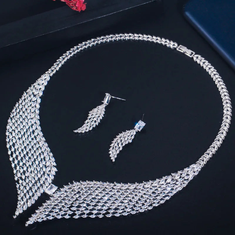 White zirconia feather necklace and matching earrings arranged as a set