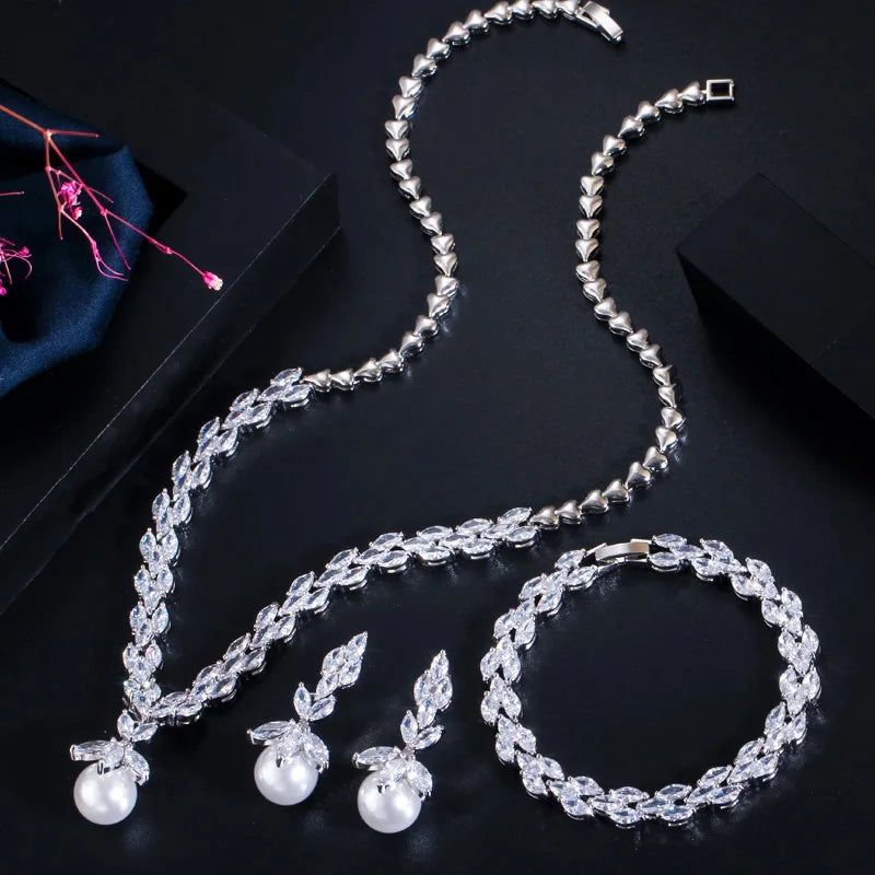 Three-piece silver-tone jewelry set with crystal leaf necklace, pearl drop earrings, and bracelet