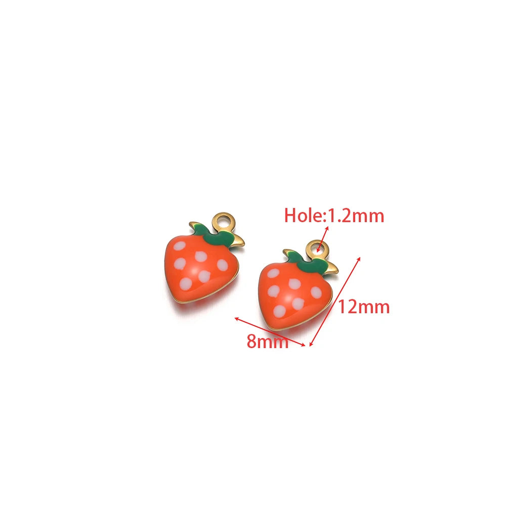 Two strawberry drop charms, orange enamel with white polka dots and green leaf tops, gold loops