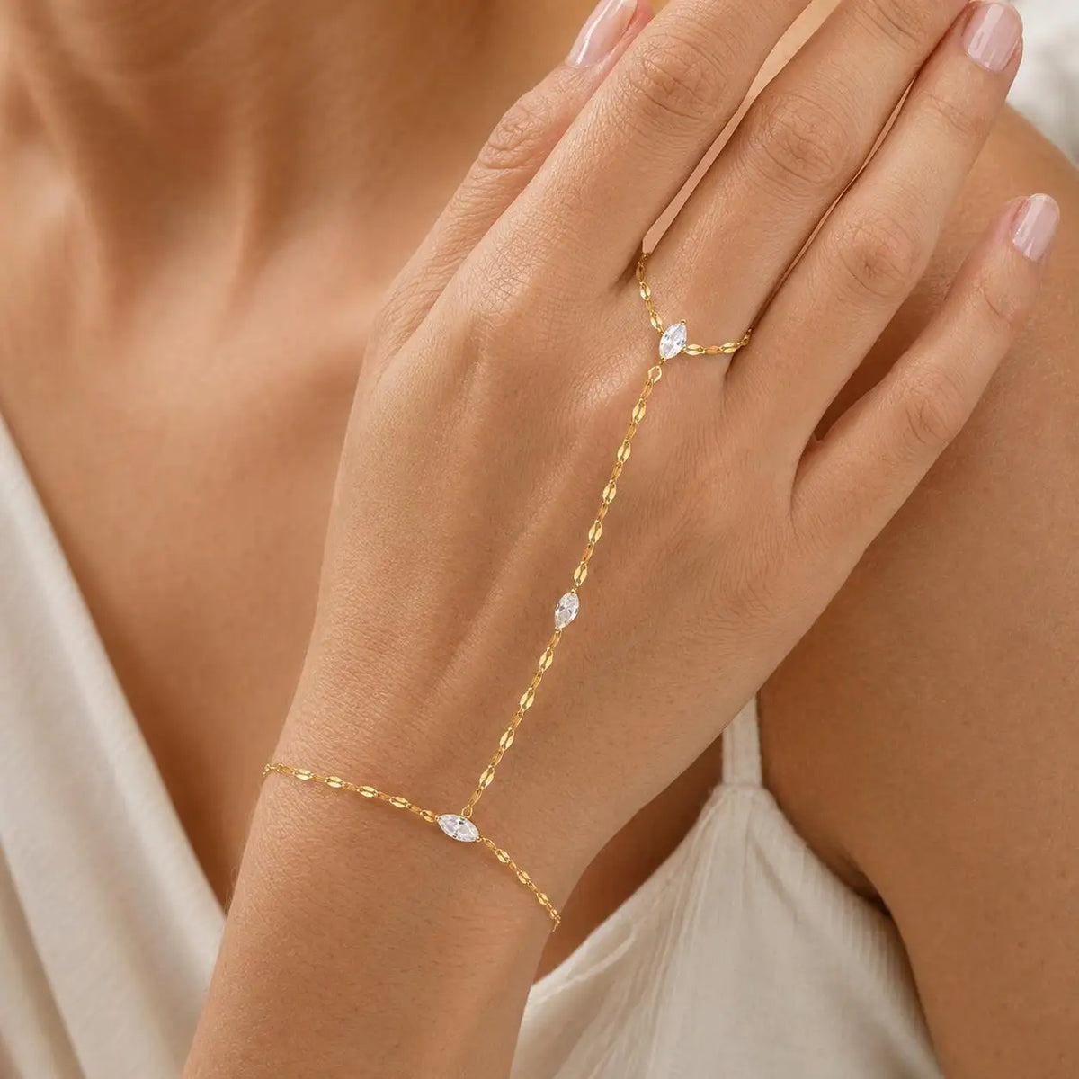Gold-tone long hand chain bracelet with oval CZ stone centerpiece