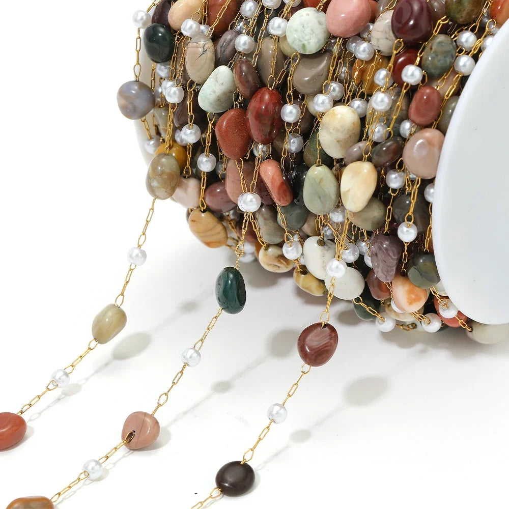 Irregular stone bead chain with pearl accents on gold-toned links, mixed beige and coral stones