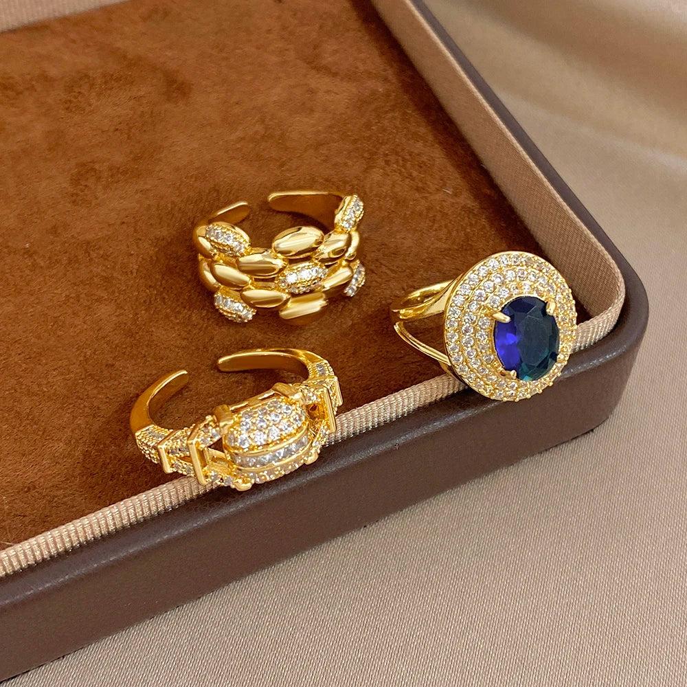 Gold-tone zircon open ring set in box: blue oval ring plus two clear crystal cuff styles