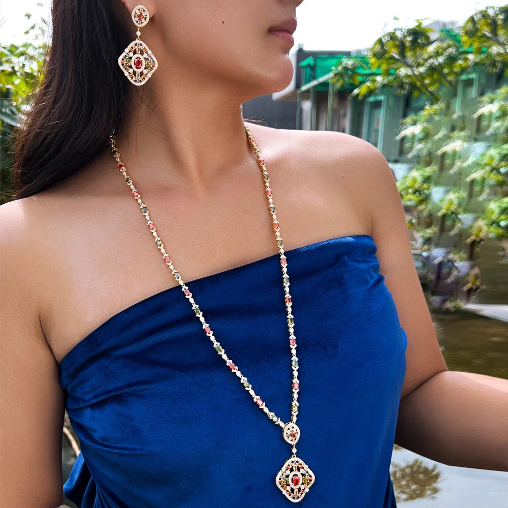 Gold-tone long necklace with red and green crystal drop earrings, worn on model