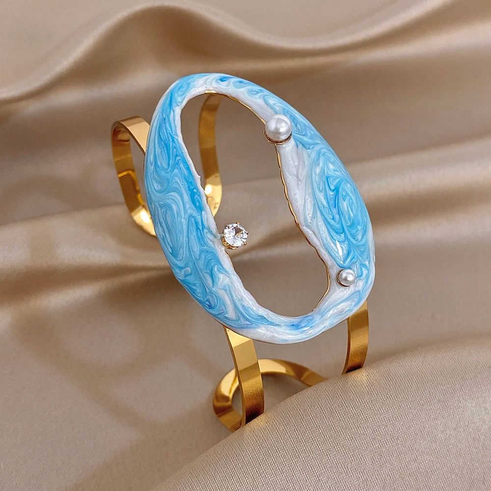Gold-plated wide cuff bracelet with blue enamel oval shell frame and pearl