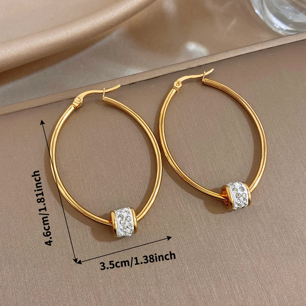 Gold-plated hoop earrings size view: 4.6 cm height, 3.5 cm width, rhinestone bands