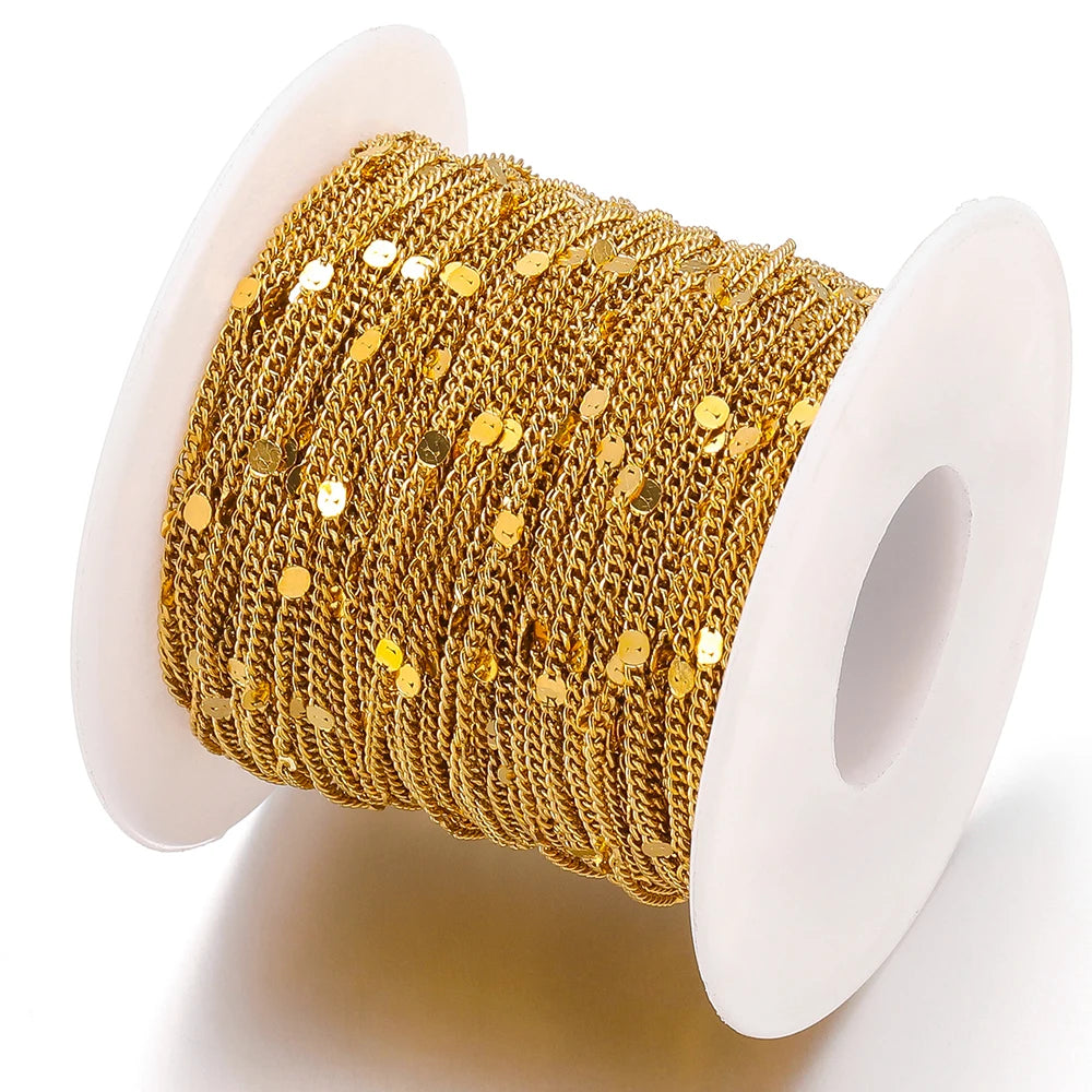 Gold textured flat oval chain on white spool, sparkly round link centers