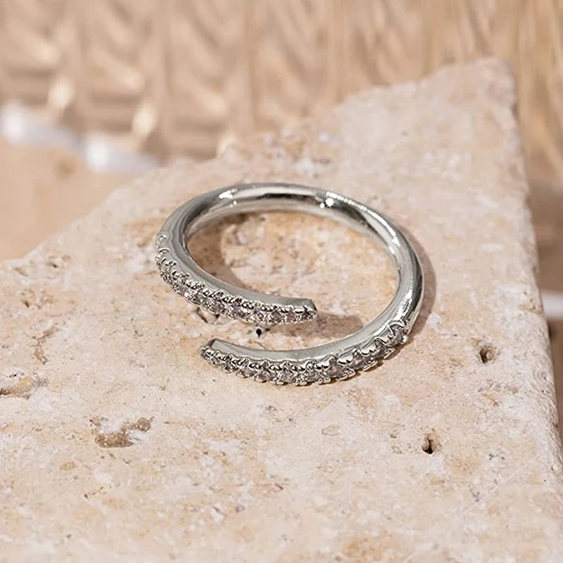 Silver open zirconia band ring with textured edges and round clear stones