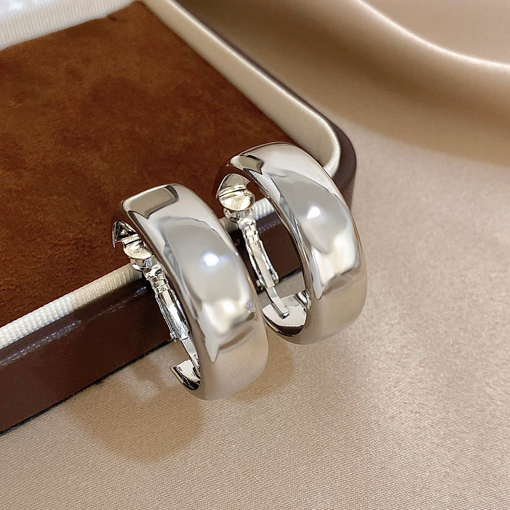 Pair of polished silver-tone wide hoop earrings with hinged clasps