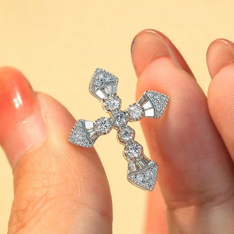 Crystal cross pendant necklace held in hand, showing faceted stone details