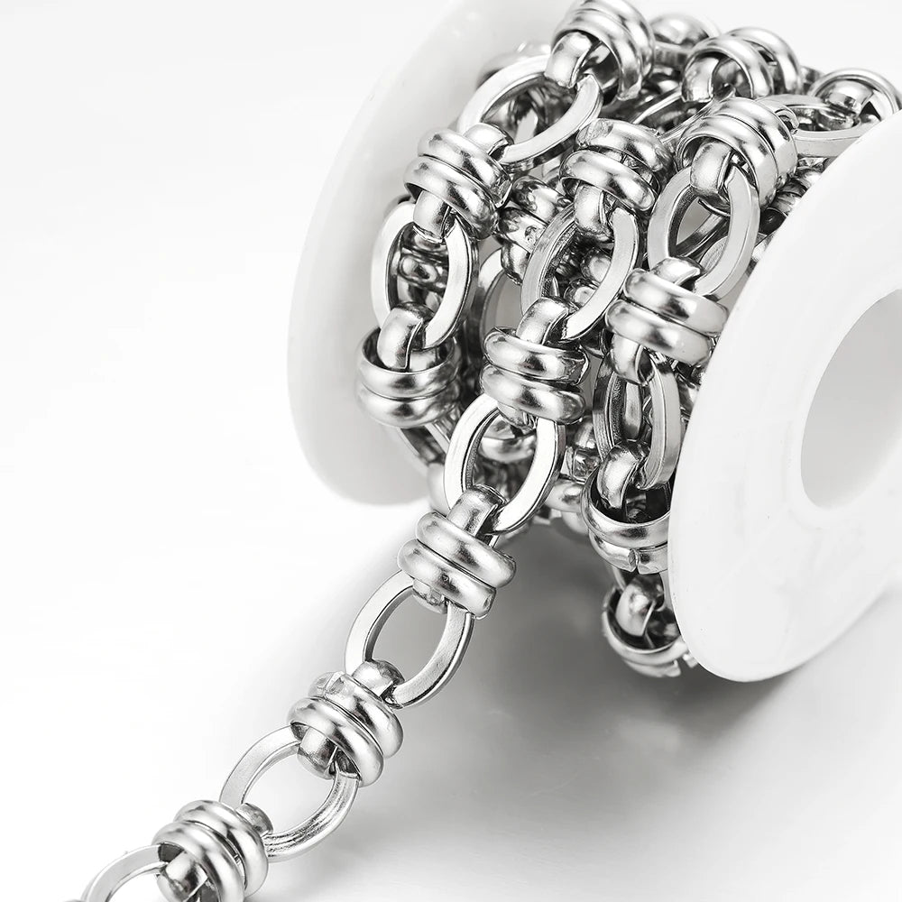 Stainless steel link chain with oval and round loops on a white holder, close-up