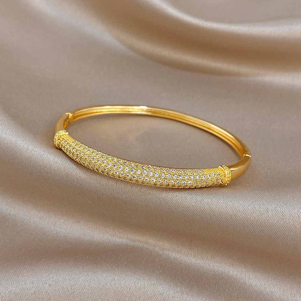 Gold-tone cuff bangle with micro-set clear zircon accents