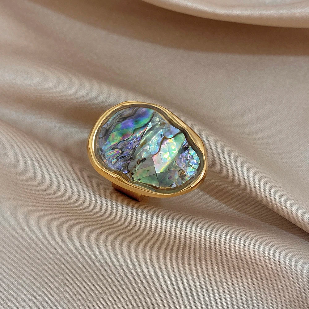 Gold-plated abalone shell ring angled view, irregular iridescent oval center