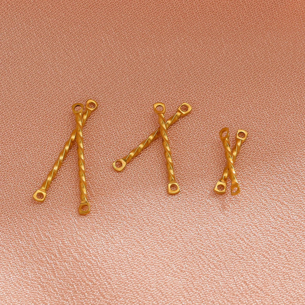 Gold twisted rod double-hole connectors, close-up of several pieces