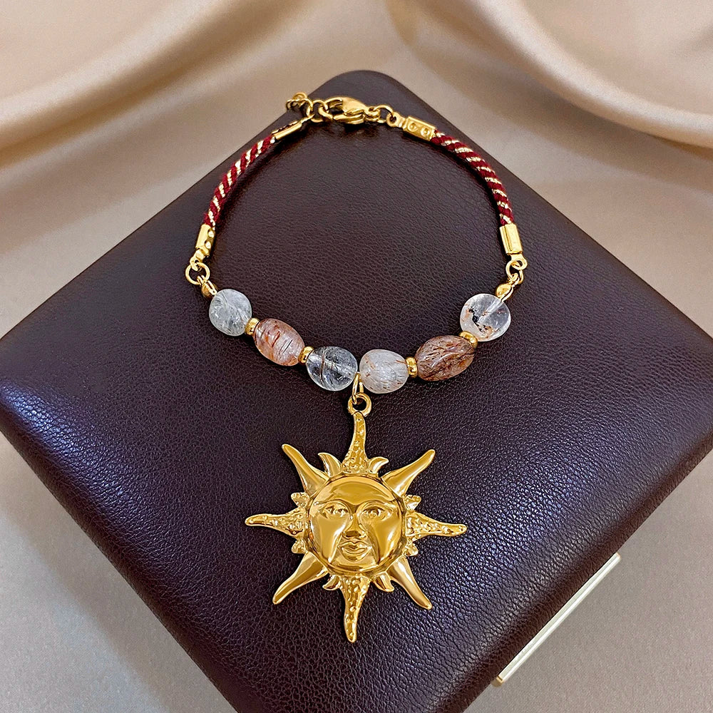 Brown-bead beaded rope bracelet with red accent cord and gold sun face charm