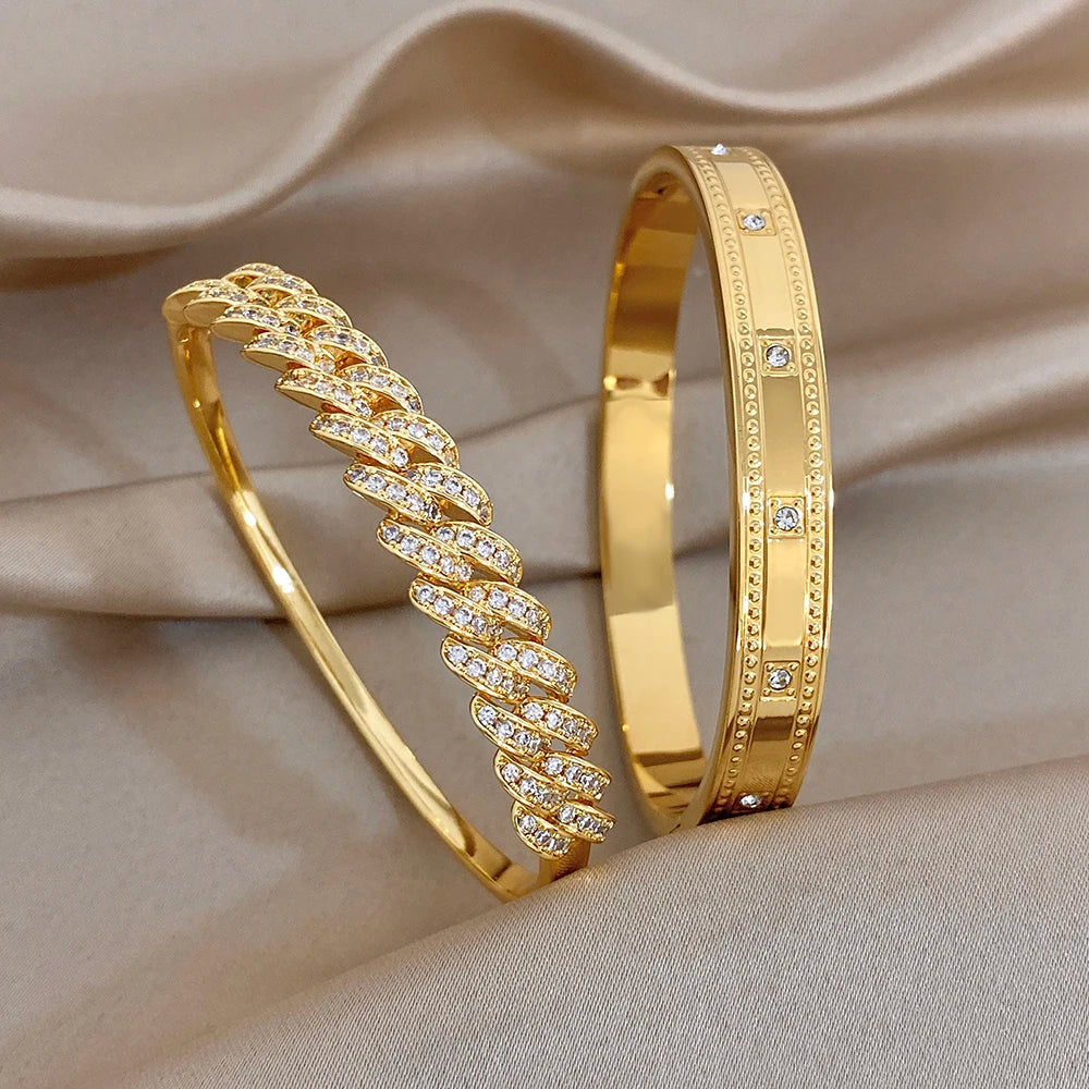 Gold tone cuff bangle with clear rhinestone geometric link band detail.