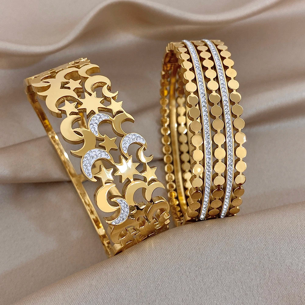 Gold-tone wide cuff bangles with star, moon cutouts and clear rhinestone accents