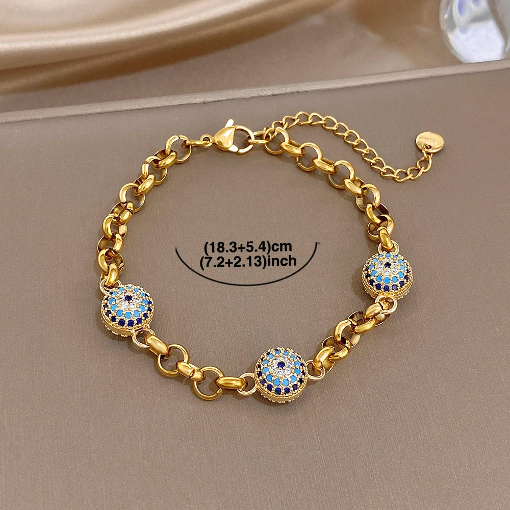 Gold-tone thick chain bracelet with blue evil-eye bead charms and small toggle clasp