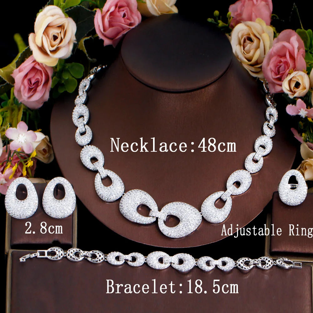Jewelry set on display: silver-tone zirconia necklace, bracelet, ring, and earrings