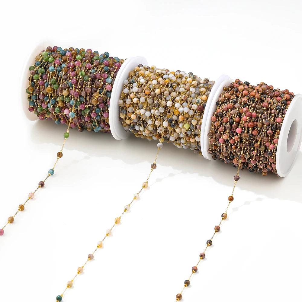 Gemstone bead chain spools with gold links and multicolor beads in purple, green, and tan