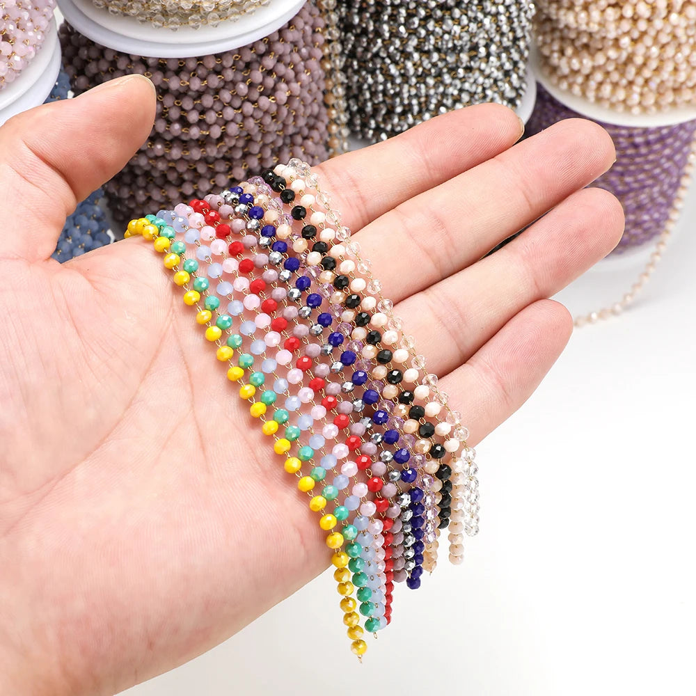 Glass faceted beaded chain with multicolor beads on black strands, held in a hand