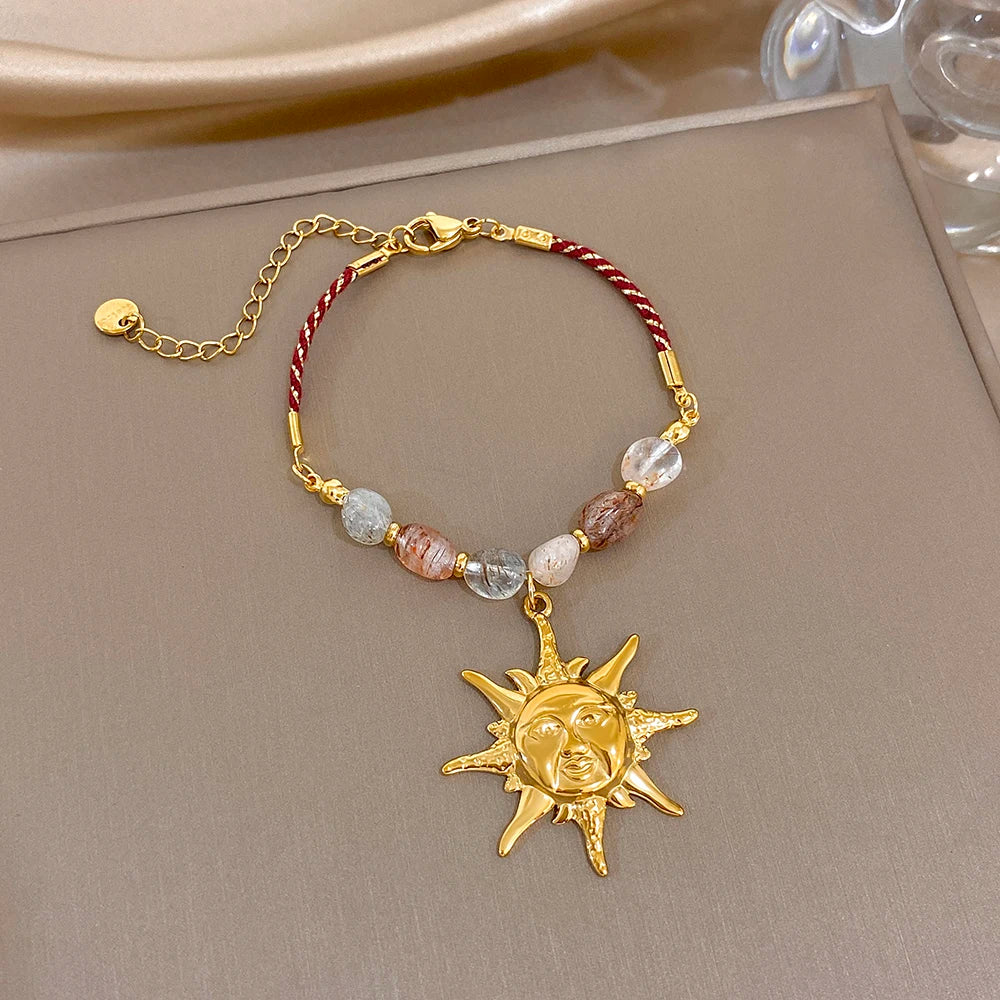 Red rope beaded bracelet with clear stones and gold sun face charm pendant