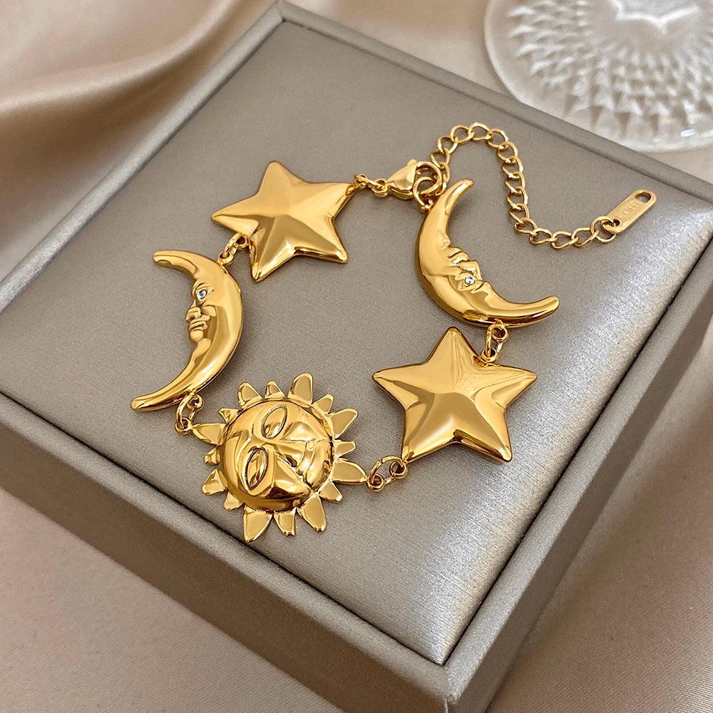 Gold-tone patchwork charm bracelet featuring crescent moons, star charms, and a sun pendant