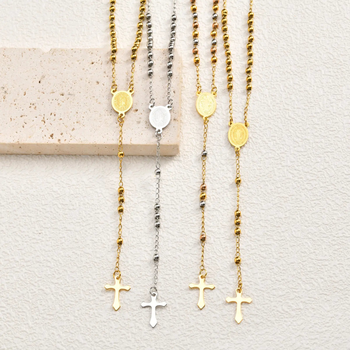 Multiple rosary necklaces with gold and silver chains, round medallions, and cross pendants