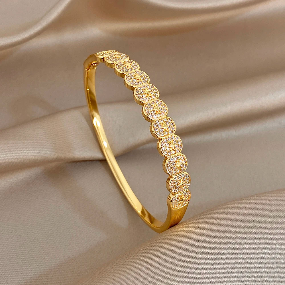 Gold-tone cuff bangle with a row of rhinestone-studded round discs