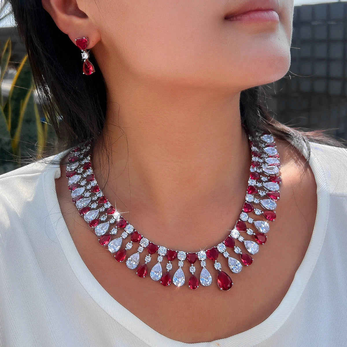 Red and clear rhinestone teardrop choker necklace with heart drop earrings, worn