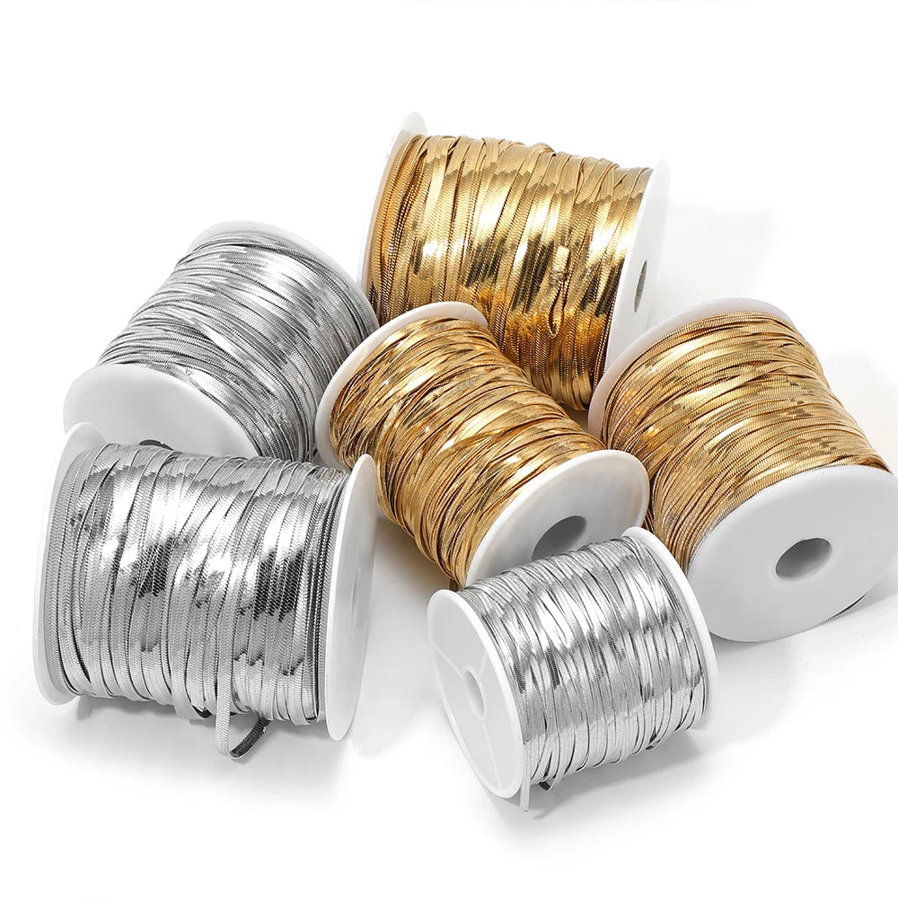 Reels of flat snake chain cords in gold and silver, coiled for DIY jewelry making