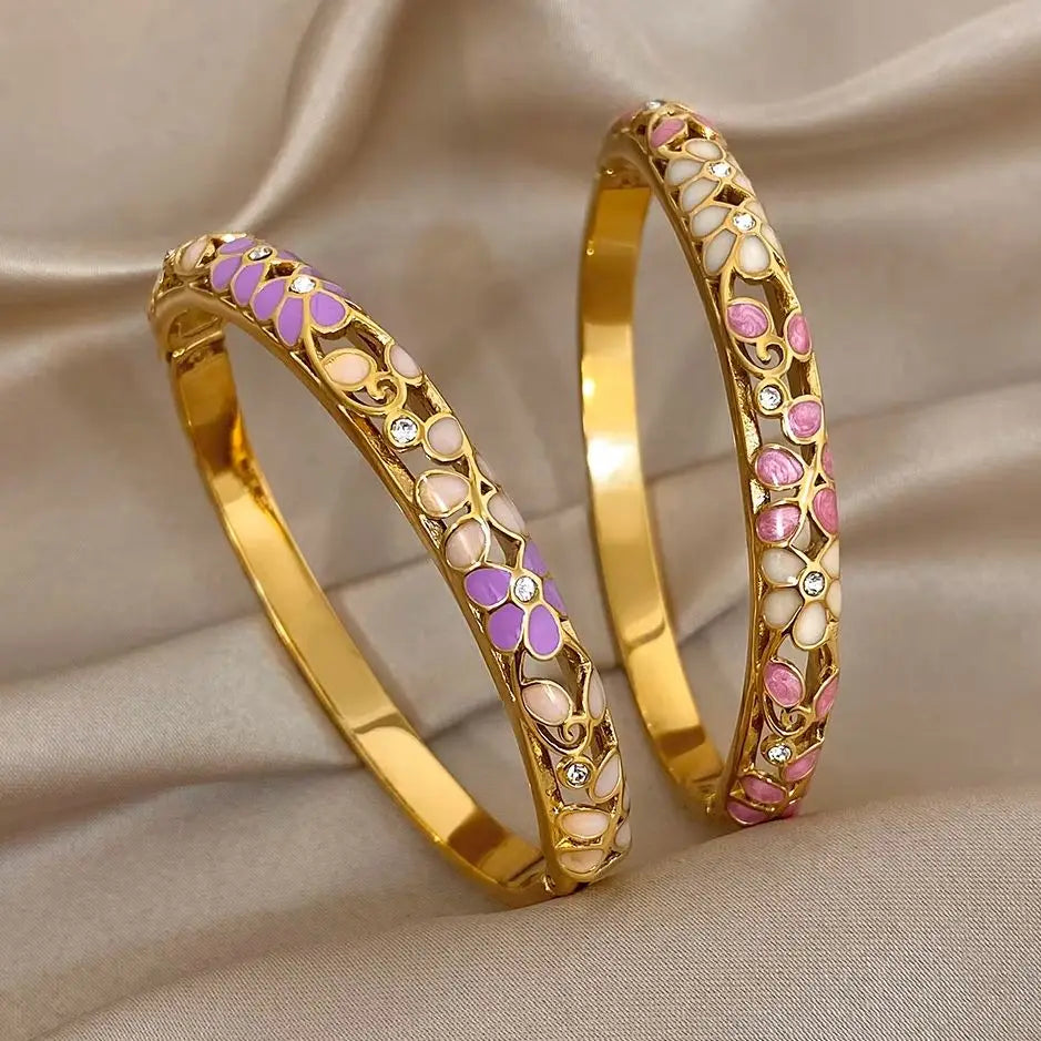 Gold-plated cuff bangles with purple and white enamel cutouts and small crystal details