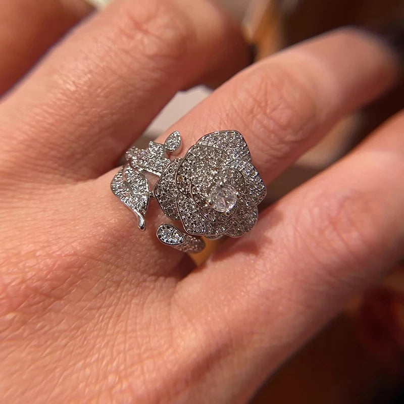 Close-up of silver-tone adjustable flower zirconia ring with center round stone and petals.