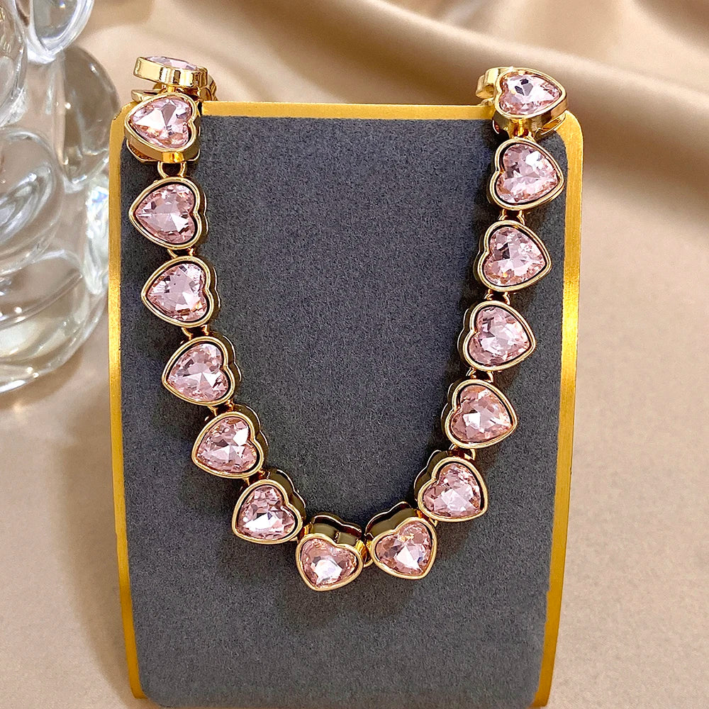 Gold-tone heart zircon link chain choker with light pink heart stones on stand