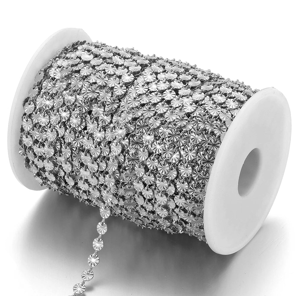 Silver-tone heart-shaped embossed link chain on a white spool