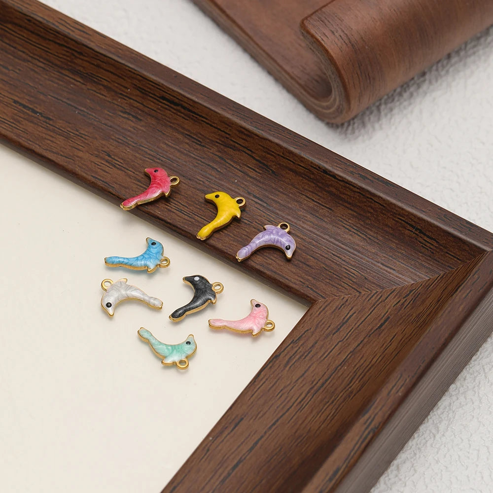 Enamel dolphin charms in mixed colors with gold-tone loops on display