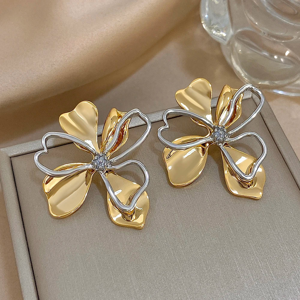 Gold-tone flower earrings with silver outline petals and sparkling centers