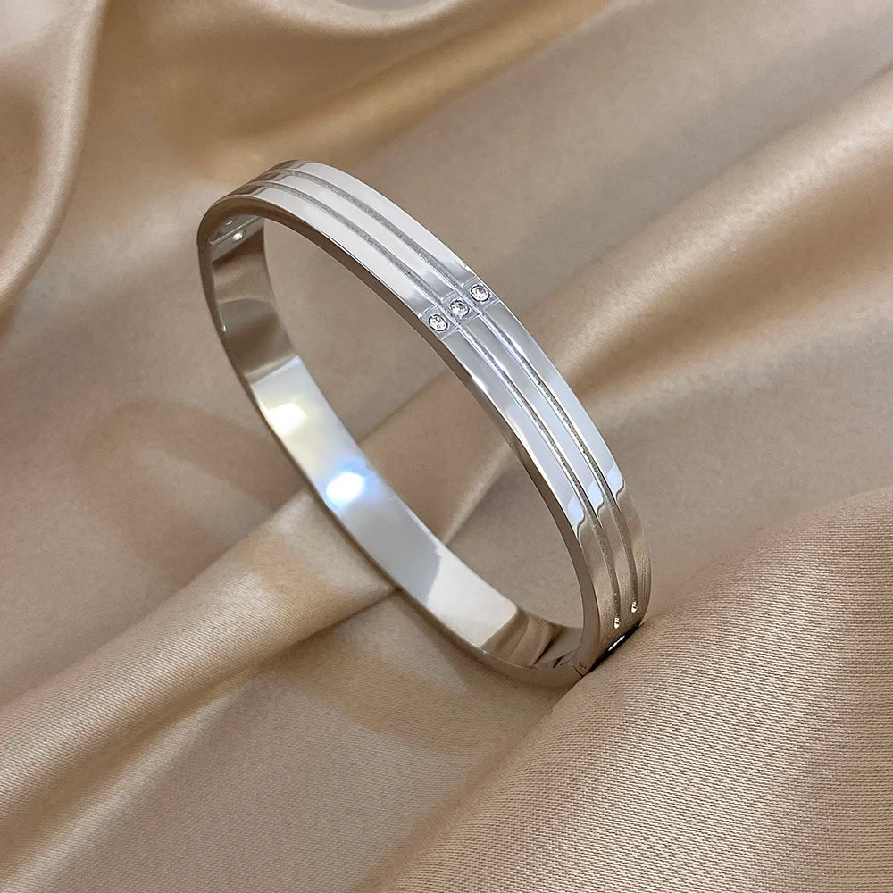 Silver-tone stainless steel wide cuff bangle with crystal stud accents