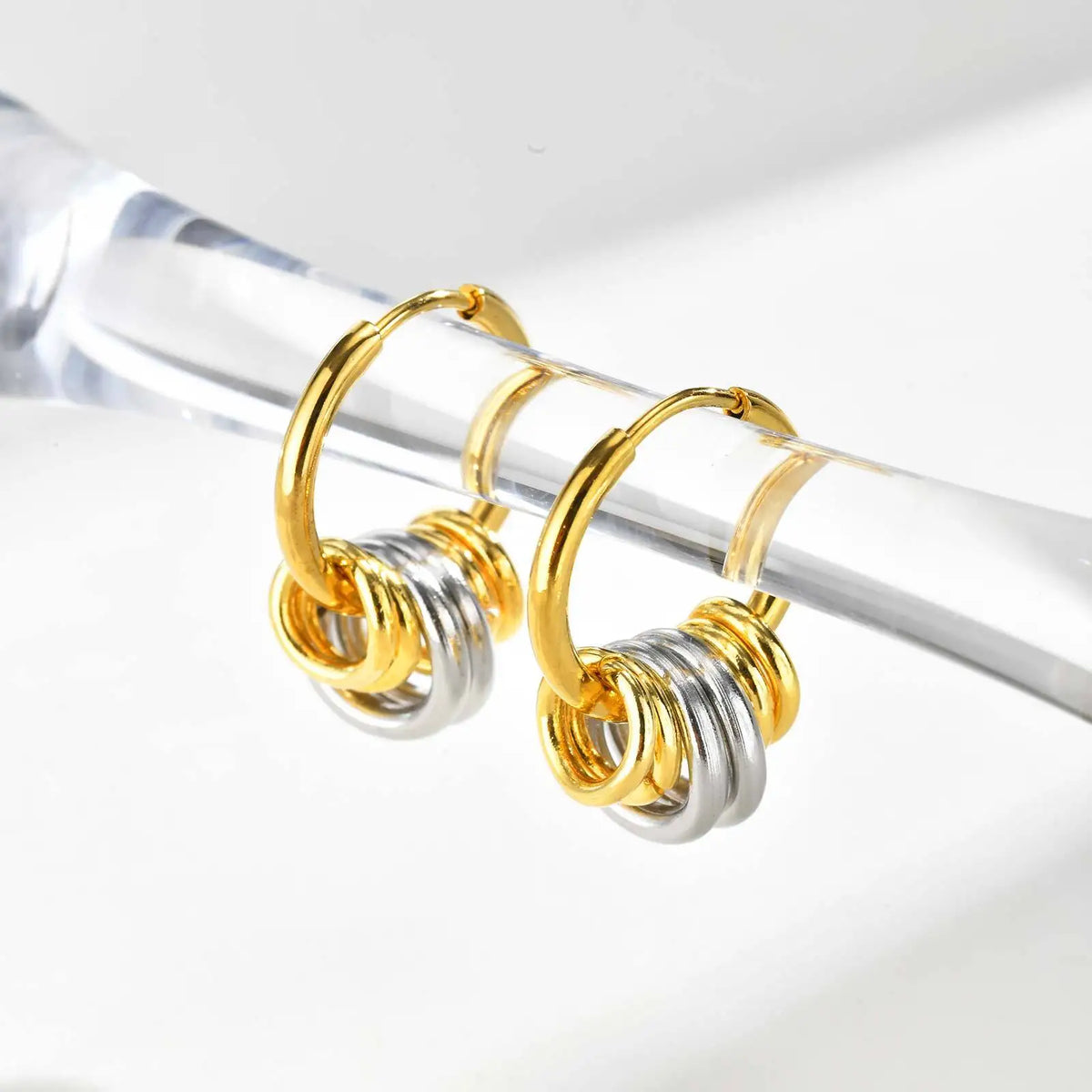 Pair of two-tone hoop earrings with gold hoops and layered silver and gold rings.