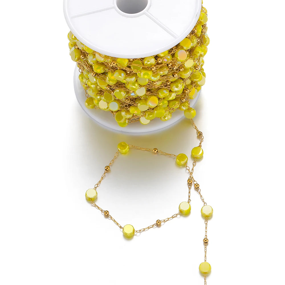 Yellow crystal bead chain with gold links, with dangling strand from a white spool
