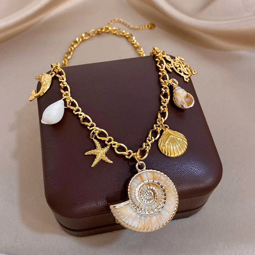 Gold-tone charm necklace and bracelet set with conch-shell pendant, starfish, and dolphin charms