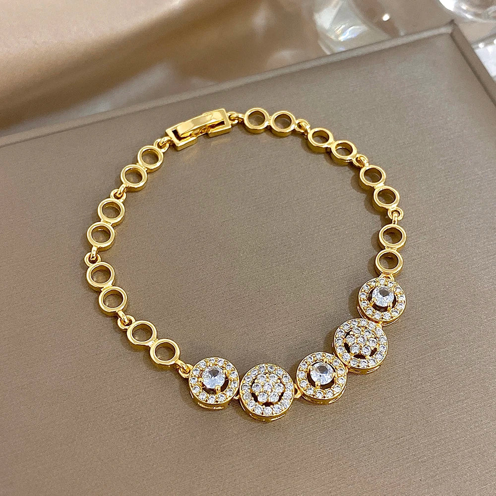 Gold-tone round-link tennis bracelet with round rhinestone drops and linked stones