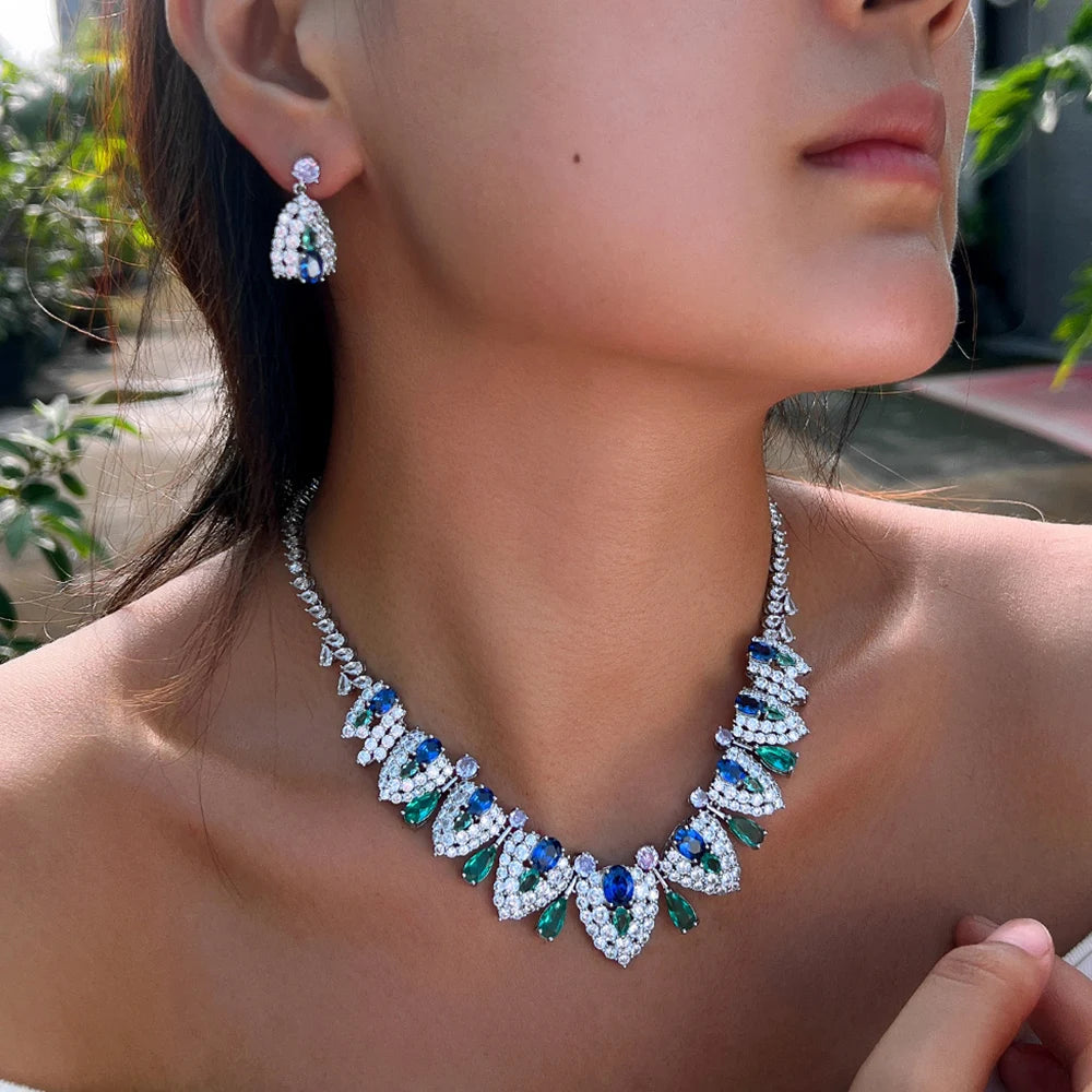 Silver-tone multi-stone necklace and dangling earring worn close up